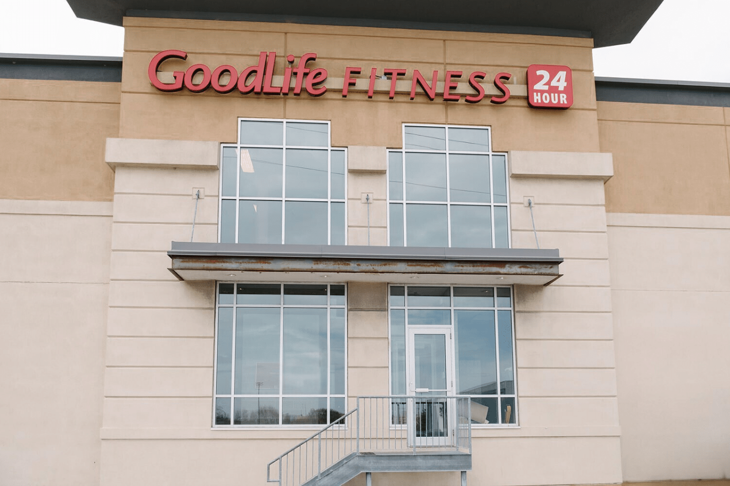 Whitby Location a Goodlife Fitness entrance with a staircase leading to a door. - Click to see schedules and fees